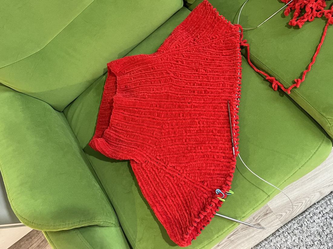 Red knit piece resting on a green sofa